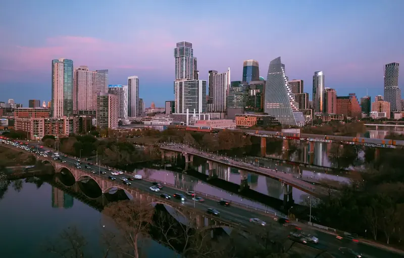 Austin skyline at dusk seen across bridges over the water